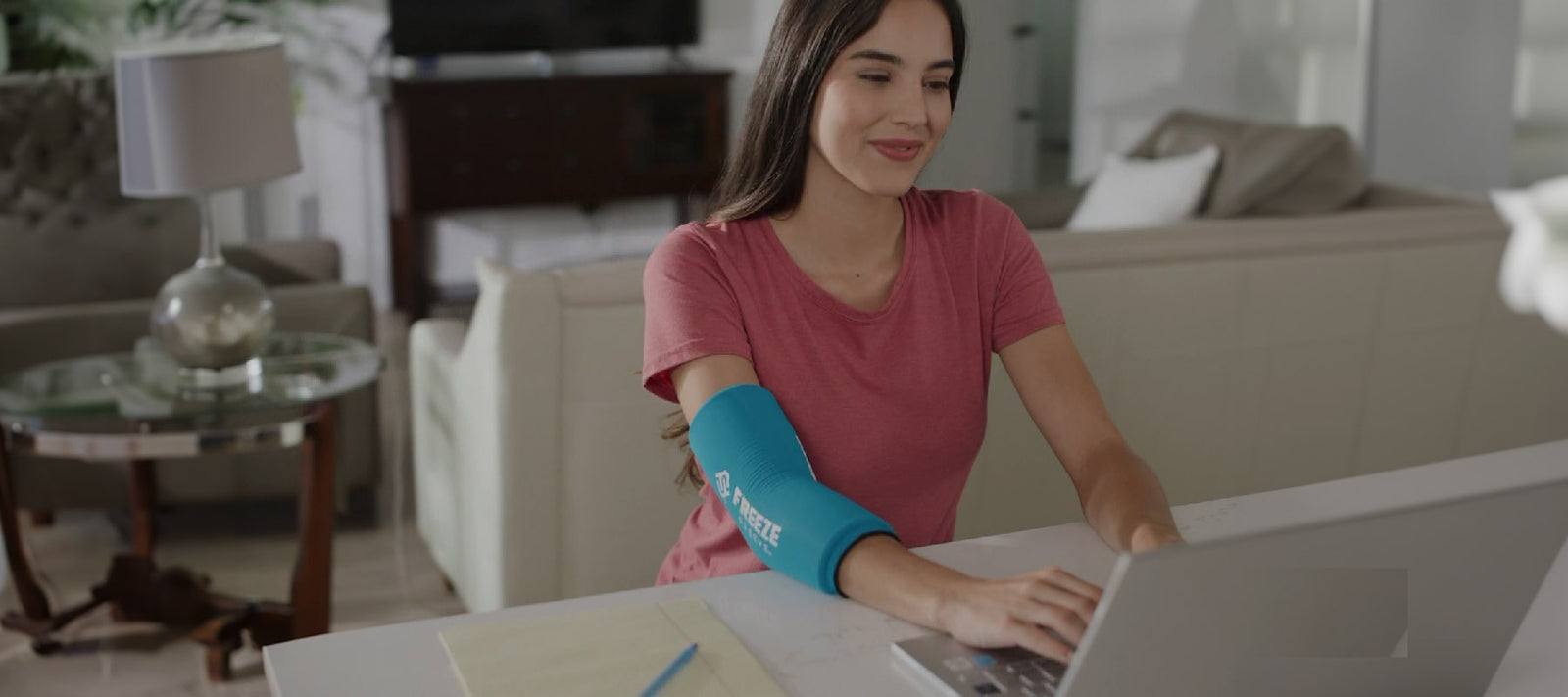 Frau verwndet eine Kühlbandage bei Ellenbogenschmerzen durch Tennisarm