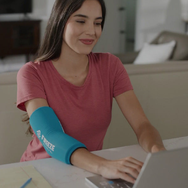 Frau verwndet eine Kühlbandage bei Ellenbogenschmerzen durch Tennisarm